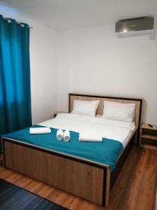a bedroom with a bed with two shoes on it at Pensiunea Corina Tulcea in Tulcea