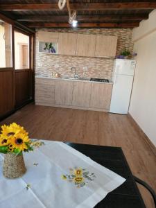 eine Küche mit einem Tisch mit einer Vase mit Sonnenblumen in der Unterkunft Pensiunea Corina Tulcea in Tulcea