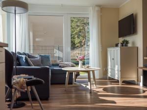 a living room with a couch and a table at Luftkurort - 5 Sterne Ferienhaus - See-Kamin-Sauna-Garten in Krakow am See