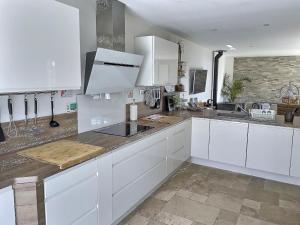 a kitchen with white cabinets and a counter top at En toute simplicité in Lavilletertre