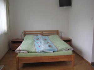 Una cama en una habitación con 2 mesitas de noche y aversión en Ferienwohnung Schellenberg, en Marktschellenberg