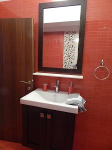 ein Badezimmer mit einem weißen Waschbecken und einem Spiegel in der Unterkunft Palm House Nikiti - Apartments Vicky in Nikiti