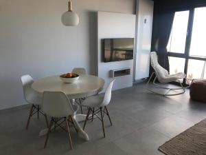 una sala da pranzo con tavolo e sedie bianchi di Luxury Seaview Apartment with free private garage a Ostenda