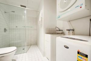 a white bathroom with a shower and a toilet at Swainson on Bent in Adelaide
