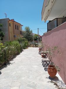 a walkway with potted plants on the side of a building at Palm House Nikiti - Apartments Vicky in Nikiti