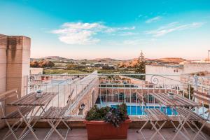 Santa Luċija的住宿－Sweet Life Gozo，阳台配有椅子,享有游泳池的景色