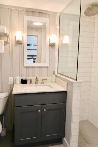 un baño con lavabo y espejo en The Bradford, en Provincetown