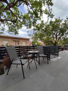 a patio with a table and chairs and trees at Stefani apartments in Methana