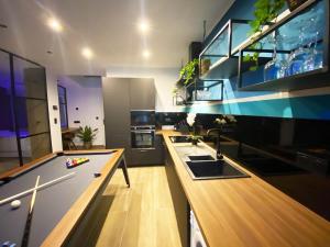 a large kitchen with a pool table in a room at Capsule Gaming balnéo & billard & babyfoot & sauna 2 chambres in Valenciennes