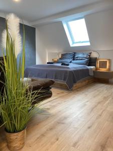my inn في شيمنيتز: غرفة نوم مع سرير وزرع الفخار