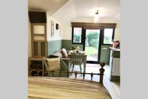 a bedroom with a bed and a table and a couch at Melford Allotment Shed-Vintage Lodge Suffolk in Long Melford