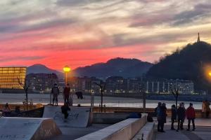 a group of people standing around a skate park at sunset at Apartamento Zurriola by SanSe Holidays in San Sebastián