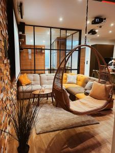 - un salon avec deux fauteuils et un canapé dans l'établissement Capsule Gaming balnéo & billard & babyfoot & sauna 2 chambres, à Valenciennes