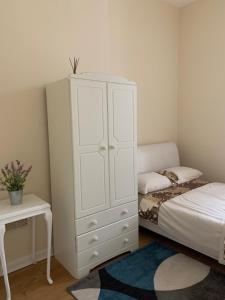 a bedroom with a white cabinet and a bed at WIGHTHOLIDAY in Ryde