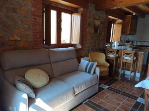a living room with a couch and a kitchen at Casa de Aldea La Xunta in Cangas de Onís