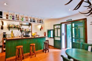 um restaurante com um bar verde com bancos em Hotel de Montaña La Hortizuela em Coto Rios