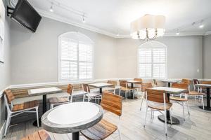 a dining room with tables and chairs and a tv at Hotolos Hollywood in Hollywood