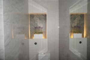 La salle de bains est pourvue de 2 fenêtres et de toilettes fleuries. dans l'établissement Hotel Don Bartolo, à Espinar