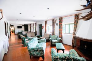 sala de estar con sofás, sillas y chimenea en Hotel de Montaña La Hortizuela, en Coto Ríos