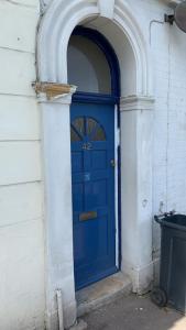 a blue door on a white building with an archway at WIGHTHOLIDAY in Ryde