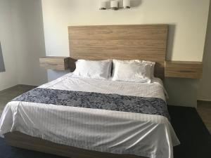 - une chambre avec un grand lit et une tête de lit en bois dans l'établissement Hotel Flamingo, à Ciudad Juárez