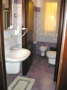 a bathroom with a sink and a toilet at Puesta De Sol Residence in Lampedusa