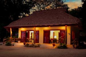a small house with a straw roof at Bluewater Maribago Beach Resort in Mactan