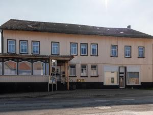 un grand bâtiment avec des fenêtres bleues sur une rue dans l'établissement Bright apartment in Harz Mountains, à Cattenstedt