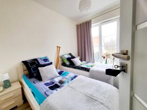 two beds in a room with a window at Apartament Mazurskie Piaski in Giżycko +36 photos