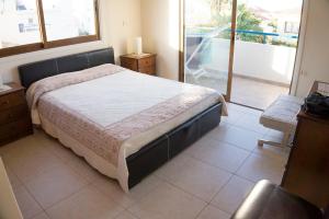 a bedroom with a large bed and a balcony at Chara Elizabeth No 2 Villa in Protaras