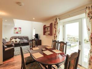 a living room with a table and a couch at Lintie Cottage in Dalbeattie