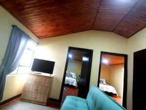 a living room with a couch and a tv and a mirror at Naturaleza Muisca in Guasca