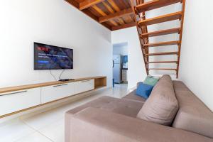 a living room with a couch and a flat screen tv at Carneiros Paradise - Casa de Luxo em Condomínio in Tamandaré