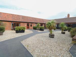 a courtyard with palm trees and a building at Beechwood in Wood Norton