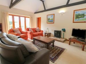 a living room with a couch and a tv at Beechwood in Wood Norton