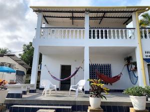 a white house with two chairs and a hammock at Cabañas Los Juanchos Coveñas in Coveñas