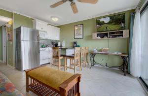 eine Küche mit einem Kühlschrank und einem Tisch mit Stühlen in der Unterkunft Nothing But Ocean in Forest Beach in Hilton Head Island