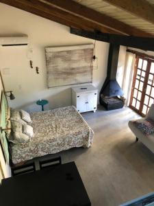 1 dormitorio con 1 cama y chimenea en Aruã Suítes & Café, en Penha