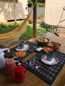 una mesa cubierta con comida y tazones de comida en Aruã Suítes & Café, en Penha