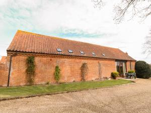 a red brick building with windows on it at Pear Tree in Wood Norton