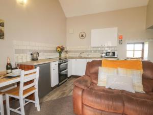 a living room with a couch and a kitchen at Carters in Staintondale
