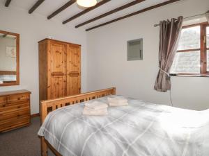 ein Schlafzimmer mit einem Bett, einer Kommode und einem Fenster in der Unterkunft Carters in Staintondale