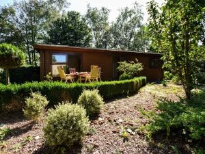 een kleine hut met een tafel en stoelen in een tuin bij Spacious Chalet in Garderen with Fenced Garden in Garderen