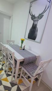 uma mesa e cadeiras com uma fotografia de um veado na parede em Apartman Iva em Nova Varoš