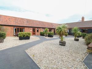 a courtyard with palm trees and a building at Sycamore in Wood Norton