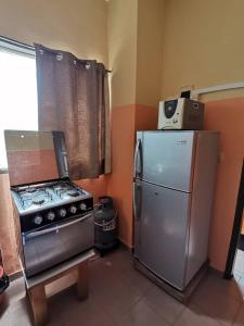 eine Küche mit einem Herd und einem Kühlschrank in der Unterkunft Appartement ABS in Abidjan