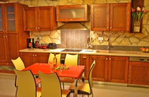 a kitchen with a red table and yellow chairs at Villa Tireda in Keri