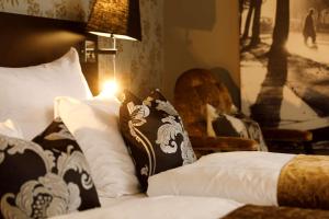 a bed with two pillows and a dog on it at Saga Hotel Oslo; BW Premier Collection in Oslo