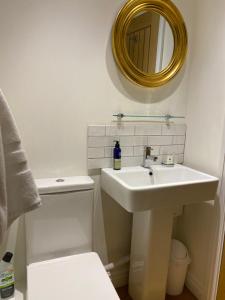 een witte badkamer met een wastafel en een spiegel bij Sawley in the Forest of Bowland - cosy cottage. in Clitheroe