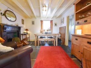 Ty Gwyn في Goodwick: غرفة معيشة مع أريكة وسجادة حمراء